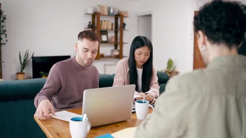 Young Adults Working on Laptops at Wooden Table