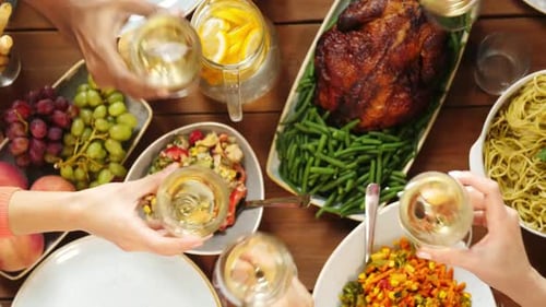 Friends Clinking Glasses Over Festive Dinner Table