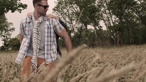 Young caucasian couple laughing running piggyback through field in autumn wind