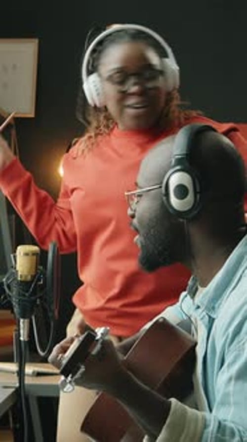 Woman Sings and Man Plays Guitar in Studio