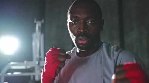Boxer in Gym Aggressive African Man Fighter Resting After Training Boxing Ready for Fight Looking at
