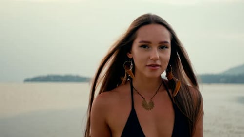 Beautiful Girl with Long Straight Hair Dancing on the Beach Watching the Sunset