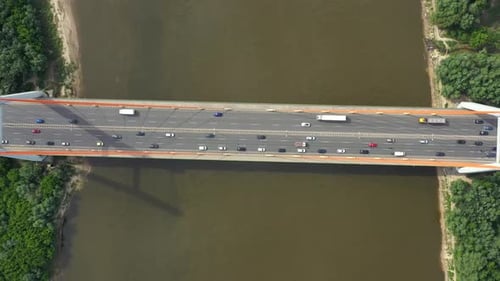 City car moving at highway bridge on background smooth river surface drone view