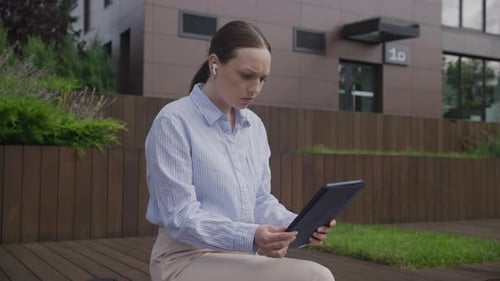 Stressed Woman Reading Bad News on Tablet Outdoors