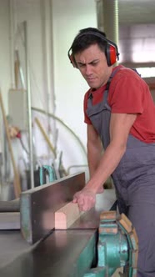 Concentrated Woodworker Trimming Wooden Plank in Workshop