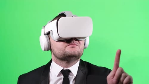 Caucasian Young Business Worker Using Virtual Reality Glasses on Green Background in Studio