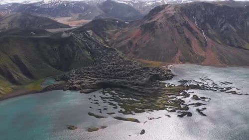 Aerial View of Lava Flow and Turquoise Lake in Iceland's Volcanic Landscape