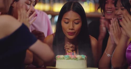 Beautiful Asian Woman is Savoring Her Birthday Festivities at a Restaurant.