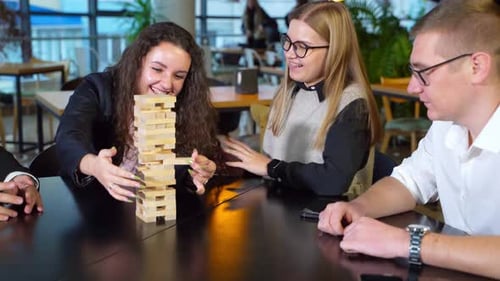 Cheerful happy group of young people play board game.