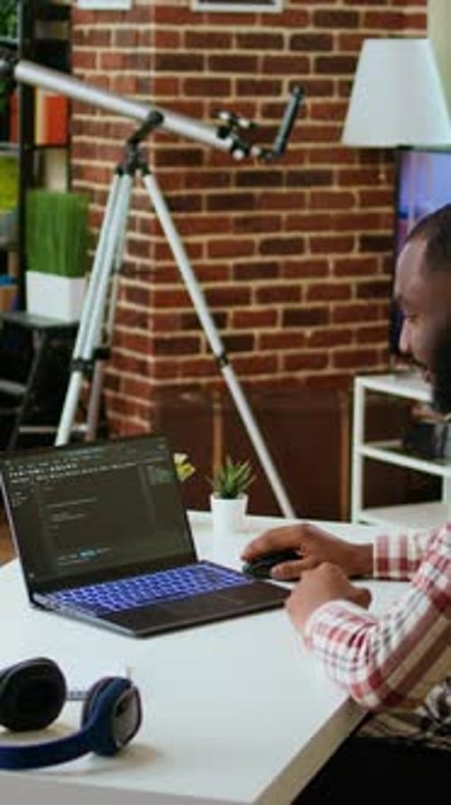 Young Adult Typing on Laptop at Desk
