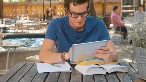Man uses tablet at a cafe in city