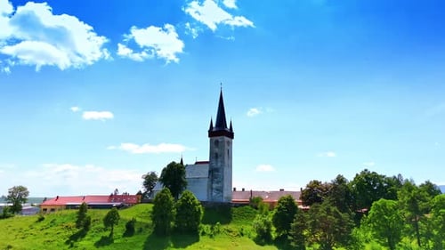 Flying closer to the old church in the rural area. Beautiful nature surrounds the building.