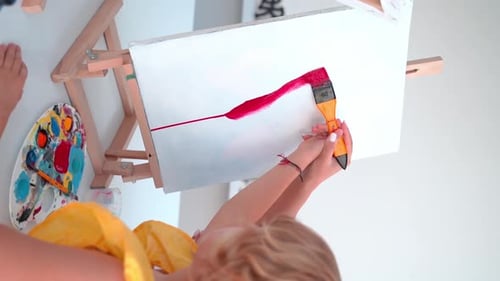 Teacher At Art School Helping Children in Art Class with Painting