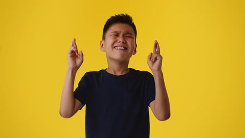 Boy Crossing Fingers Hoping for Good Luck