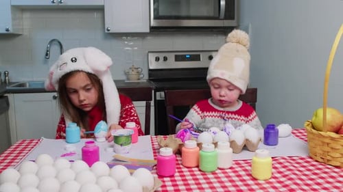 Christ is Risen Baby Boy and Girl Child Paint Easter Eggs Table in the Kitchen