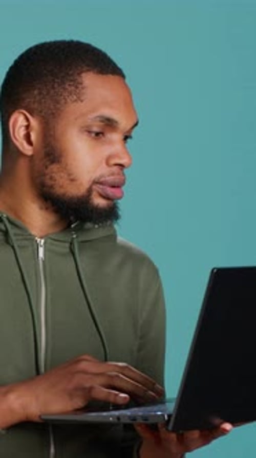 Вертикальное видео: человек печатает на клавиатуре ноутбука и проверяет электронную почту, обрадованный хорошими новостями