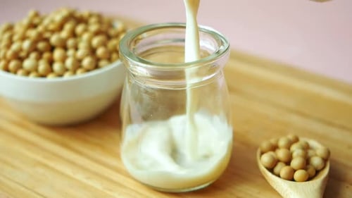 Slow Motion of Soy Milk Pouring in a Glass Jar
