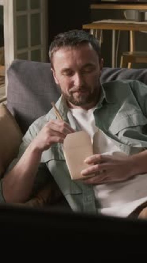 Man and Woman Eating Takeout Noodles on Couch
