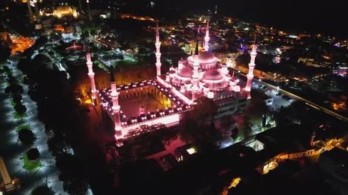 Drone Pulls Back Revealing Illuminated Blue Mosque and Cityscape