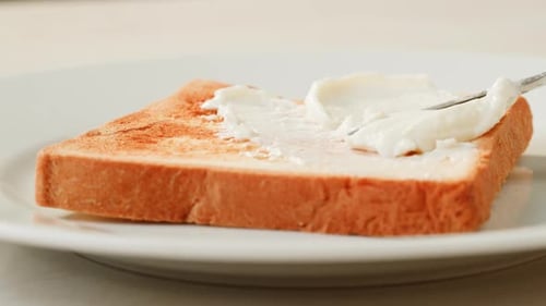 Spreading White Spread on Toast for Breakfast