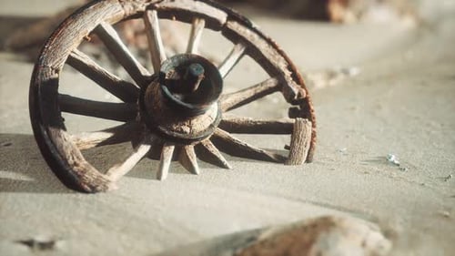 Old Broken Wooden Wheel Buried in Desert Sand