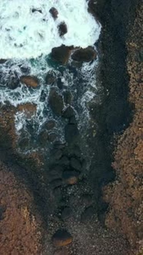 Reversing overhead social ratio aerial video of The Giant's Causeway in Bushmills, Northern Ireland