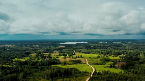 Vue aérienne d'une route de campagne avec des nuages de pluie qui arrivent. Paysage de forêt verdoyante
.