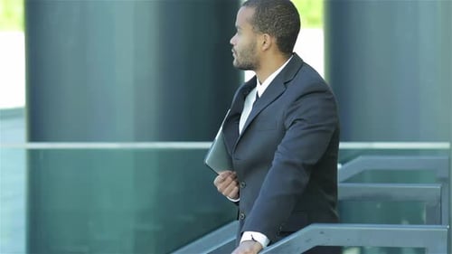Confident Man Holding Tablet in Urban Setting