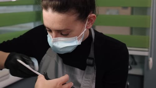Manicurist Filing Nails With Mask and Gloves