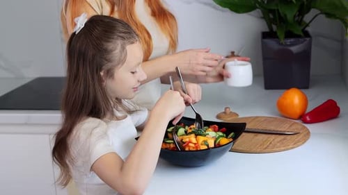 Mother and daughter are preparing a salad. Concept of organic farm products and healthy eating