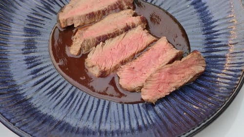 Sliced Steak and Gravy on Decorative Blue Plate