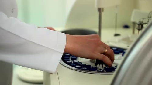 Scientist or Technician taking blood tubes with bar code put into specimens chemistry test analysis