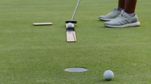 Golf Ball Putted Into a Hole on Green