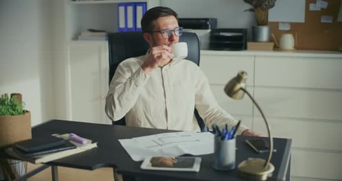 Relaxed Successful Businessman In Office Drinking Coffee