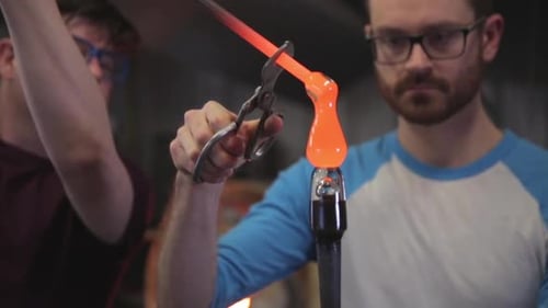 Glassblowers Shaping Molten Glass Art with Hand Tools