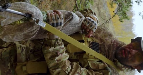 Vertical Video of a Wounded Soldier with a Blood on the Face Looking at Camera and Take Off His