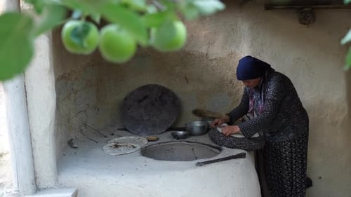Peasant Woman Baking Traditional Tandoori Bread In The Village Oven