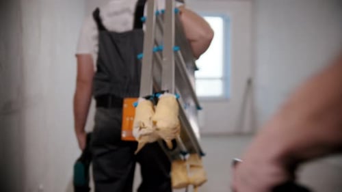Construction Workers Carrying Tools Into Room