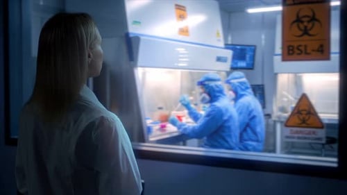 Scientist Watching Two Colleagues Working in Virology Lab