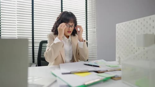 Frustrated Asian young businesswoman overwork late in office workplace.