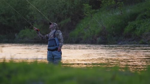 Fly fishing. Fisherman casts fly on the river at sunset. Caucasian amateur angler fishing on the riv