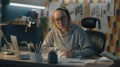 Creative Designer in Home Based Studio Stops Sketching and Looks at the Camera