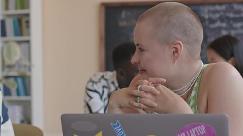 Young Girl Chatting with Friend and Smiling in College Classroom