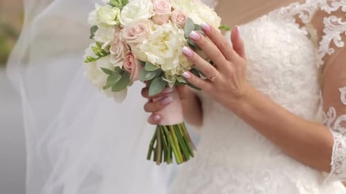 Bride Holds Wedding Bouquet in Elegant Lace Dress