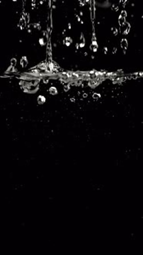 Water Droplets Splashing on Black Background in Close-up