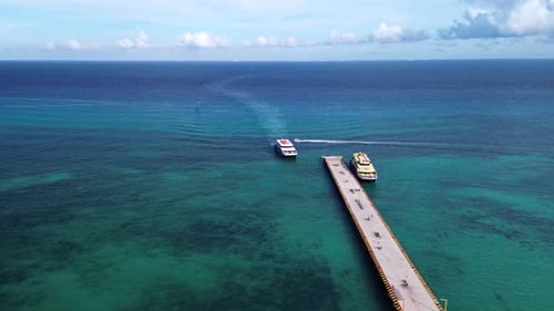 Vista aérea do cais de balsas que se estende em águas azul-turquesa e cercada por uma paisagem marinha serena