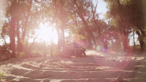 ATV Riders Splashing Through Sandy Terrain at Sunset