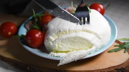 Knife Cutting Open Delicious Fresh Mozzarella on Plate