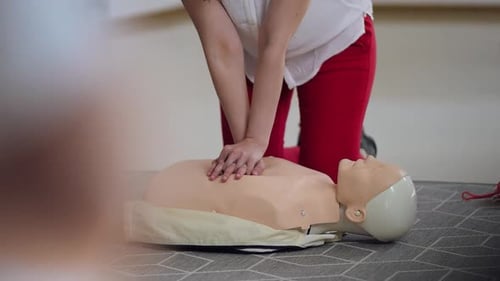 Learning CPR techniques with a training dummy during a lifesaving workshop at a community center