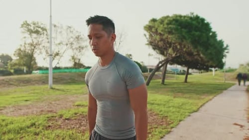 Young man walking along the path in the park